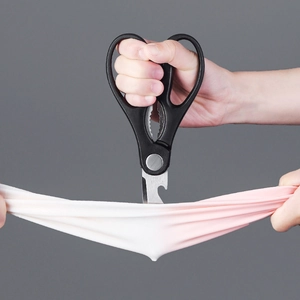 Durable stainless steel kitchen scissors cutting fabric with ergonomic black handle grips