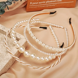 Elegant pearl headband set in white and gold on a luxurious satin and stone backdrop