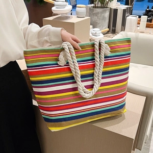 Bunte gestreifte Damen Segeltuch Tasche, groessere laessige Schultertasche in Handansicht.