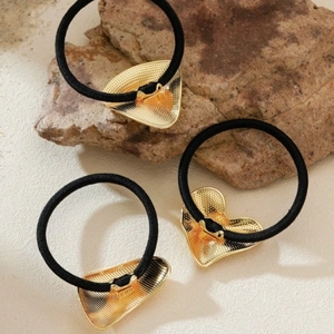 Golden heart and triangle metal hair ties on natural stones with black elastic bands