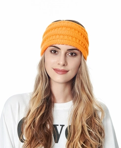 Détail du bandeau d'hiver en tricot orange vif avec maille torsadée épaisse et texture chaude