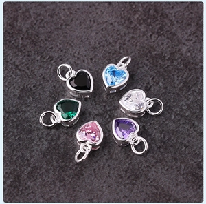 Macro shot of s925 silver heart pendants set with colorful zircons in six vibrant colors
