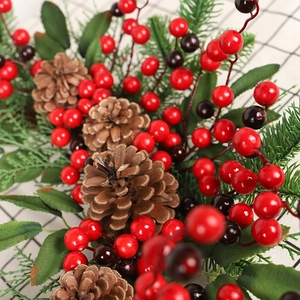 Christmas wreath with red berries, pine cones and green needles on plaid background