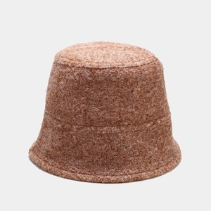 Vue détaillée de la texture en laine d'agneau marron sur un chapeau seau d'hiver