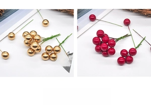 Detail of decorative Christmas berries with shiny red and gold finishes on bendable stems