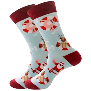 Detail of light blue Christmas socks with surfing Santa and reindeer cartoon patterns