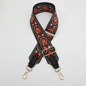 Detail of adjustable canvas bag strap with colorful ethnic embroidery and gold metal hooks