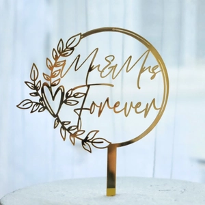 Golden acrylic Mr & Mrs wedding cake topper with elegant leaves and heart design