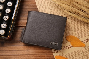 Macro detail of dark brown genuine leather wallet with lychee texture on vintage wooden desk
