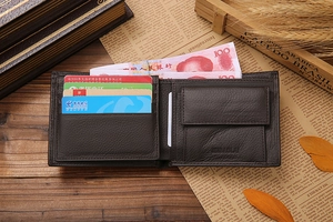 Detail of dark brown leather bi-fold wallet with card slots and snap coin pocket