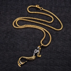 Minimalist gold mermaid pendant necklace for men and women on a dark textured surface