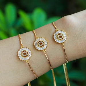 Adjustable gold letter D bracelet with sparkling cubic zirconia on a model with garden background