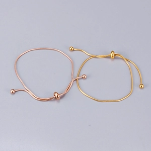 Detail of rose gold and gold snake chain bracelets with adjustable sliding bead closure