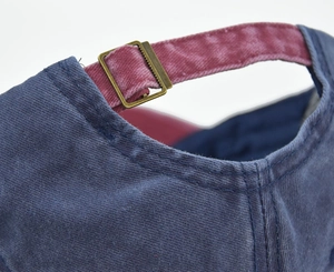 Close-up of vintage washed cotton baseball cap with adjustable metal buckle and stitching