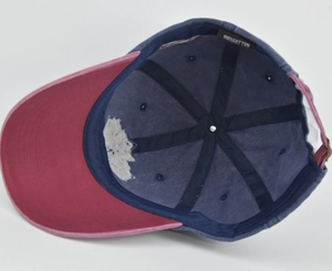 Detailed interior of red and navy cotton baseball cap showing 100% cotton wash label