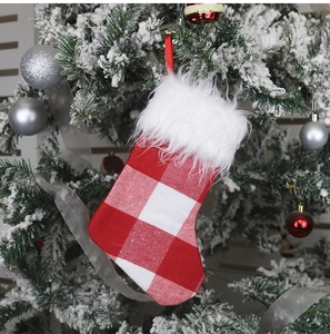 Plaid Christmas stocking with white faux fur cuff hanging on a decorated tree