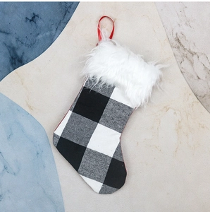 Detail of Christmas stocking with black and white plaid pattern and plush white faux fur trim