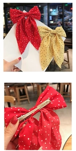 Detail of red and yellow polka dot bow hair clips with metal spring back clip