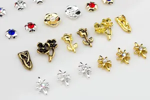Macro view of assorted vintage 3D metal rose and floral nail art charms with rhinestones