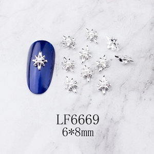 Detail showing 6x8mm silver octagonal star nail charm with white pearl on marble