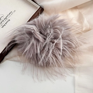 Detailed close-up of fluffy gray faux fur scrunchie on elegant silk fabric background