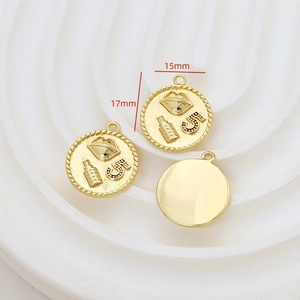 Detail of 15mm gold-plated circular pendants with embossed number 5 and perfume motifs