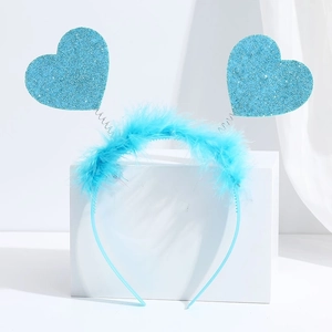 Detailed view of blue glitter heart headband with feather accents on a display stand