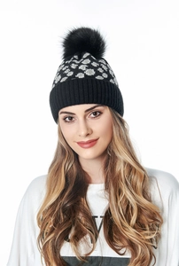 Detailed texture of leopard print knit beanie with large black faux fur pompom for winter