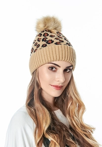 Detail of leopard print knitted beanie with large faux fur pompom and ribbed cuff
