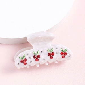 Pearly white hair claw clip featuring sparkling red and green rhinestone cherry design
