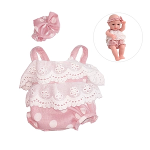 Close-up of pink polka dot doll romper and matching headband with white lace details