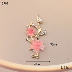 Detailed macro view of cherry blossom pendant with gold alloy, resin and white pearls
