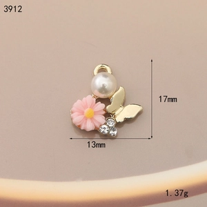 Macro shot of 13x17mm flower alloy pendant with pink daisy, white pearl and gold butterfly