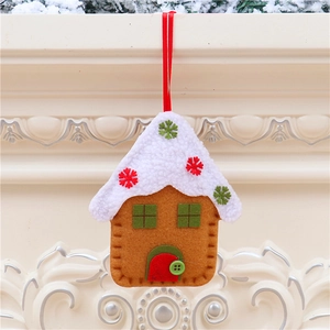Close-up of a handmade brown gingerbread house felt ornament hanging on a festive mantel
