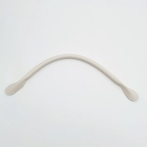 Detail of cream leather handbag strap featuring pre-punched sewing holes and padded core