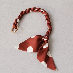 Polka dot silk scarf handbag handle strap with gold circular metal buckles and fabric weave
