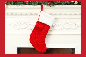 Gros plan d'une chaussette de Noël en tricot rouge avec fourrure blanche sur une cheminée