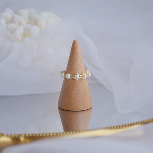 Detailed view of a wave-shaped 14k gold plated ring with natural freshwater pearls