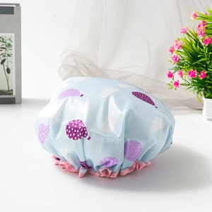 Close-up of waterproof shower cap with blue hot air balloon print and pink ruffle edge