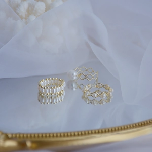 Three elegant 14k gold plated rings with natural freshwater pearls on a mirror
