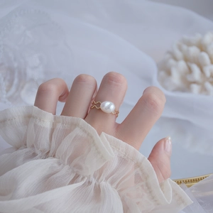 Close-up of 14k gold plated wavy ring with natural freshwater pearl on model's finger