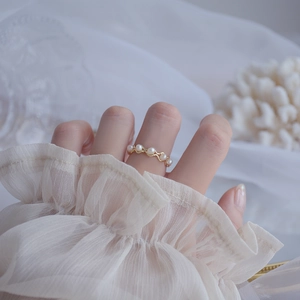 Detailed view of 14k gold-plated wavy ring featuring natural freshwater pearls on finger