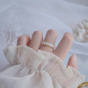 Detailed macro view of 14k gold plated ring with natural freshwater pearls on model