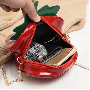 Red strawberry shaped patent leather crossbody bag showing internal capacity for daily items