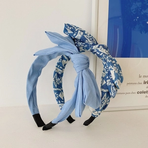 Detail of light blue and geometric pattern fabric bow headbands on a white stand