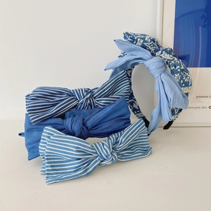 Set of four blue fabric headbands with bow ties in solid, striped, and floral patterns