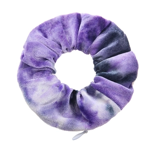 Macro shot of purple tie-dye velvet hair scrunchie featuring a hidden zipper pocket detail
