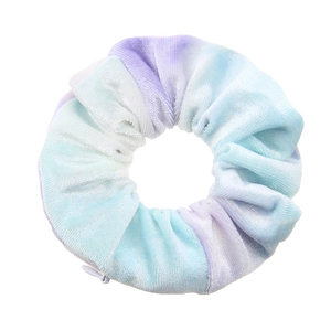 Detail view of tie-dye plush velvet scrunchie with a hidden zipper in blue and purple