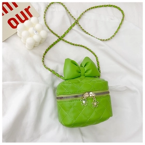 Close-up of green quilted crossbody bag with a large bow and flower-shaped zipper detail