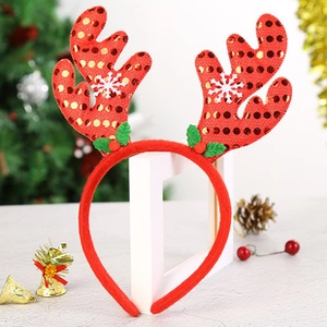 Detail of red sequined reindeer antlers headband with white snowflake and holly berry accents